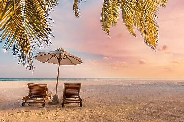 Beautiful tropical island, couple chairs umbrella under palm tree leaves, paradise sea sand sky. Summer travel landscape amazing vacation beach