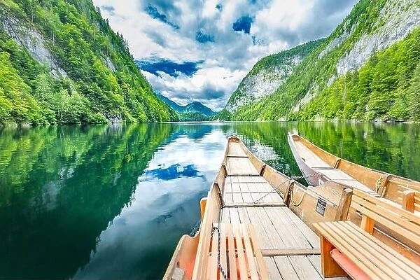 Beautiful view of traditional wooden rowing boat on scenic. Summer mountain lake pass scenic morning light at sunrise clouds over blue sky green trees