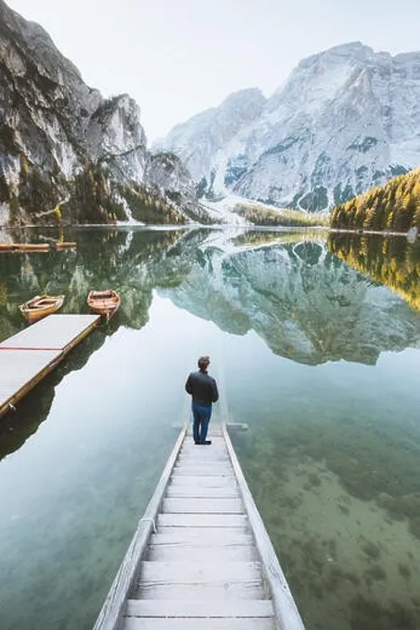 Framed Print : Beautiful view of a young man standing on wooden stairs watching the sunrise at famous Lago di Braies the Dolomites Framed Print : Beautiful view of a young man standing on wooden stairs watching the sunrise at famous Lago di Braies the Dolomites