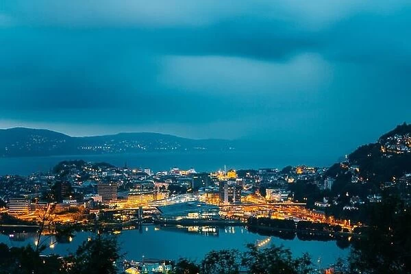 Bergen, Norway. Aerial View Cityscape Of Bergen And Harbor From Mountain Top In Blue Hour. City In Summer Evening Or Night Illuminations Lighting