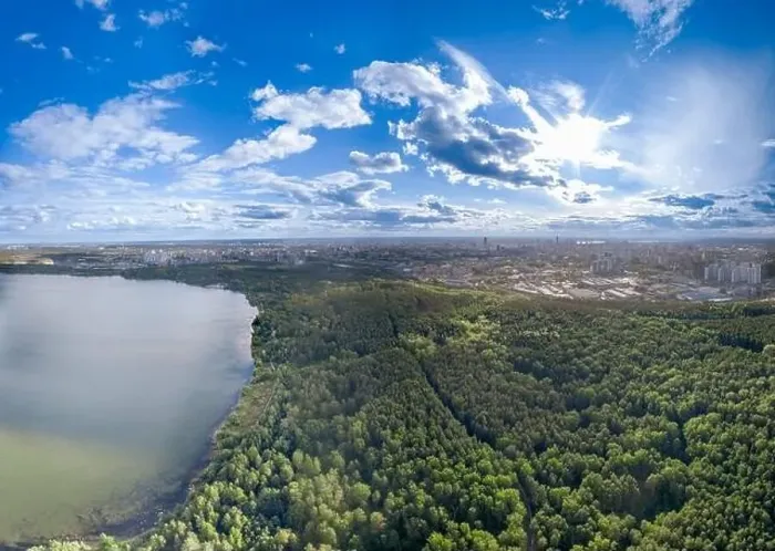 Framed Print : Big lake with green shores in bright sun light and city on horizon Framed Print : Big lake with green shores in bright sun light and city on horizon
