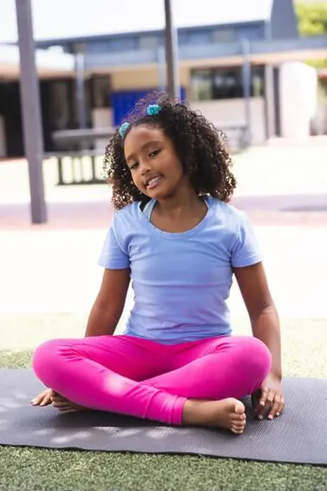Framed Print : Biracial girl practices yoga outdoors at school Framed Print : Biracial girl practices yoga outdoors at school