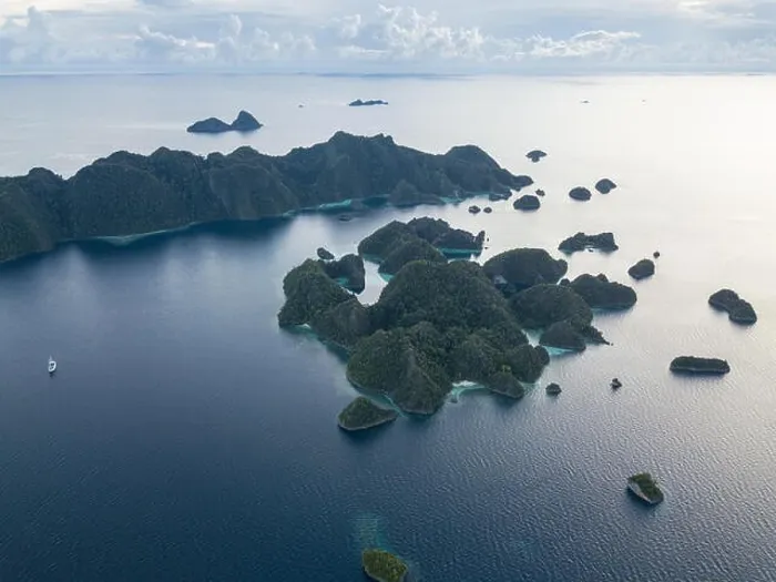 Framed Print : A bird's eye view shows dramatic limestone islands rising from the peaceful, tropical seascape in Raja Ampat, Indonesia Framed Print : A bird's eye view shows dramatic limestone islands rising from the peaceful, tropical seascape in Raja Ampat, Indonesia