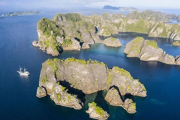 A bird's eye view shows healthy reefs surrounding remote limestone islands in Raja Ampat. This area is known for its incredible marine biodiversity
