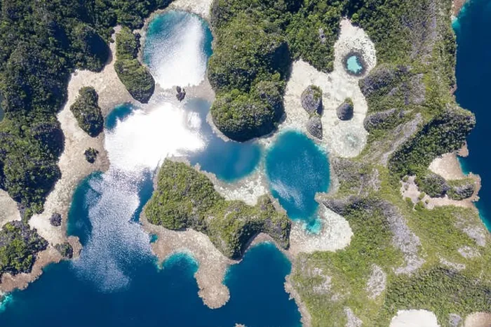 Framed Print : A bird's eye view shows healthy reefs surrounding remote limestone islands in Raja Ampat. This area is known for its incredible marine biodiversity Framed Print : A bird's eye view shows healthy reefs surrounding remote limestone islands in Raja Ampat. This area is known for its incredible marine biodiversity