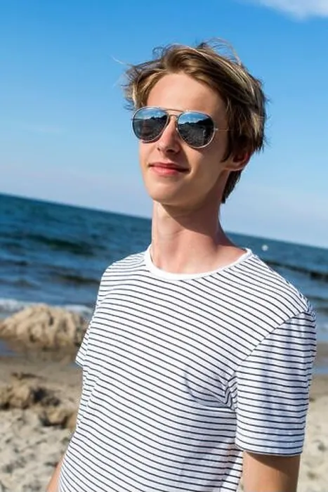 Framed Print : blond teenage boy in mirror glasses standing on the sandy beach Framed Print : blond teenage boy in mirror glasses standing on the sandy beach