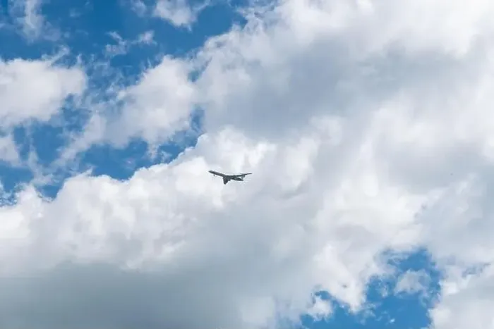 Framed Print : in a blue sky with beautiful clouds flies an airplane Framed Print : in a blue sky with beautiful clouds flies an airplane