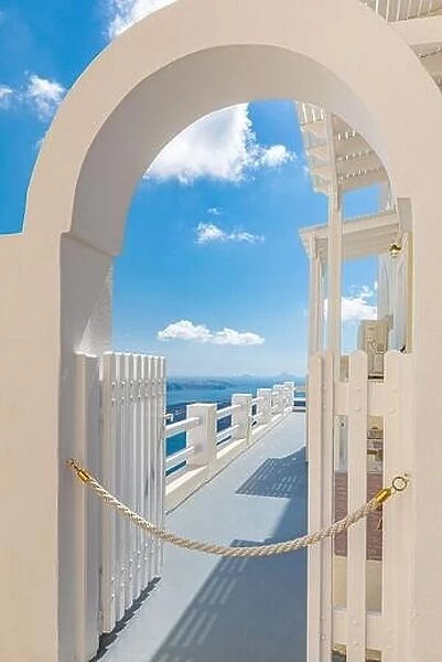 Blue sky with white gate and beautiful sea view. Amazing caldera with white architecture. Luxury summer travel and romantic vacation destination mood