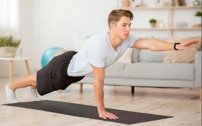 Framed Print : Body care at home and fitness. Young man with fitness tracker training