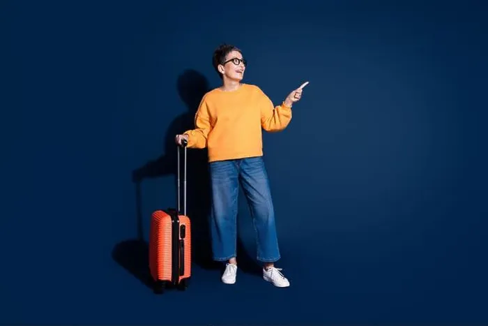 Framed Print : Full body photo of mature woman traveling suitcase point look empty space dressed stylish yellow clothes isolated Framed Print : Full body photo of mature woman traveling suitcase point look empty space dressed stylish yellow clothes isolated