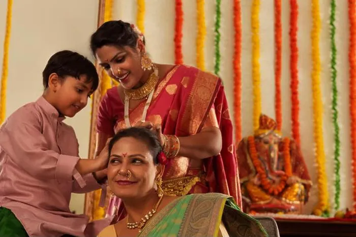Framed Print : Boy helping his mom to tie his grandmother's hair during Ganesh Chaturthi Framed Print : Boy helping his mom to tie his grandmother's hair during Ganesh Chaturthi