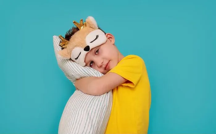 Framed Print : a boy in pajamas hugging a pillow. Banner with blue background and copy pasta Framed Print : a boy in pajamas hugging a pillow. Banner with blue background and copy pasta