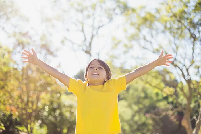 Framed Print : Boy standing with arms outstretched in park Framed Print : Boy standing with arms outstretched in park