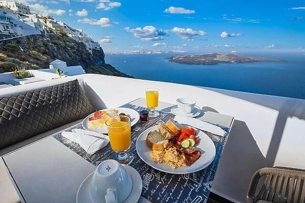 Breakfast time in Santorini in hotel. Luxury mood with fresh omelet and fruits with juice over sea view. Luxurious summer traveling holiday background