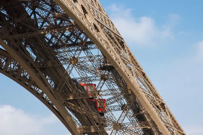 Framed Print : Two bright red elevators climbing up one of Eiffel Tower iron girders bringing tourists to the first floor Framed Print : Two bright red elevators climbing up one of Eiffel Tower iron girders bringing tourists to the first floor