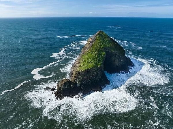 Bright sunlight shines on a solitary sea stack off the northern coast of Oregon, not far from Tillamook. This coastline has many beautiful viewpoints
