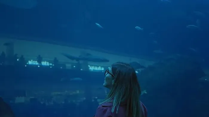 Framed Print : A brunette woman admires marine life at the dubai aquarium, reflecting travel and underwater tourism