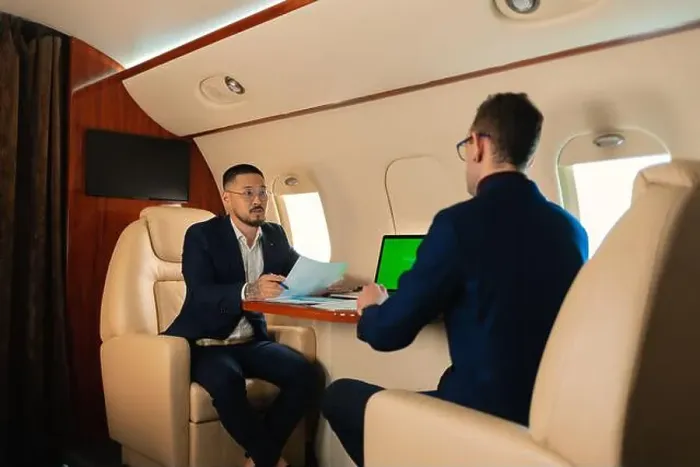 Framed Print : Two Businessman CEO couple in eyeglasses sitting inside a private jet airplane and talking about work shaking hands
