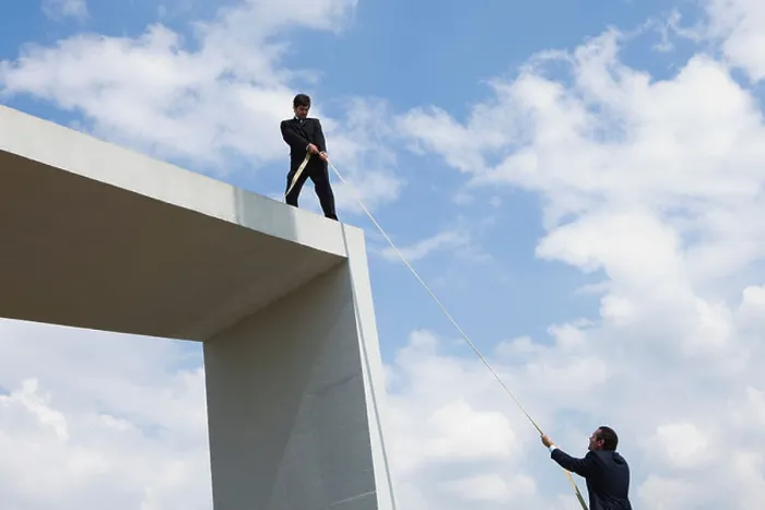 Framed Print : Businessman lends helping hand to colleague