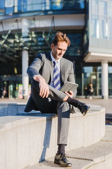 Framed Print : businessman makes a rest in the city and works with a tablet