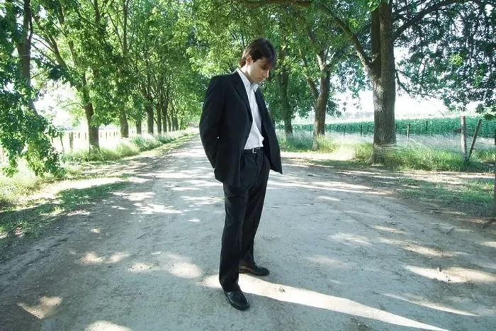 Framed Print : Businessman standing in rural road, looking down
