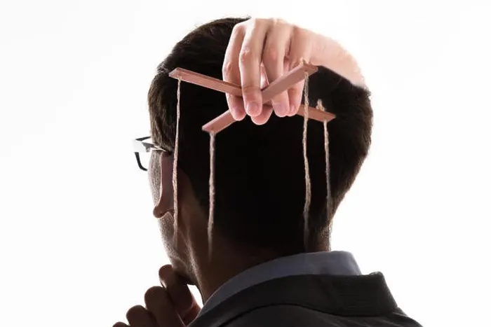 Framed Print : A Businessman's Hand Manipulating Marionette With String Against White Background Framed Print : A Businessman's Hand Manipulating Marionette With String Against White Background