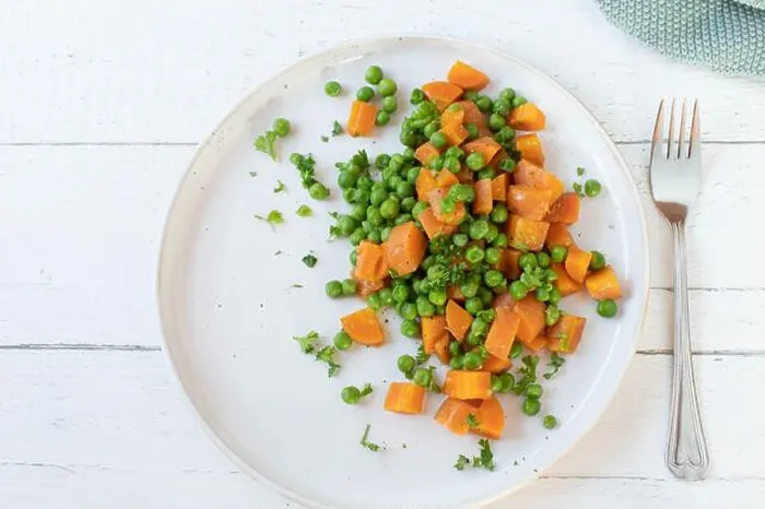 Framed Print : Buttered peas and carrots on a plate isolated on a white plate on light wooden background with fork. Flat lay Framed Print : Buttered peas and carrots on a plate isolated on a white plate on light wooden background with fork. Flat lay