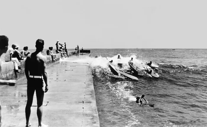 Framed Print : California surfers catching a wave along the Newport Harbor jetty in Corona del Mar in the early 1930s Framed Print : California surfers catching a wave along the Newport Harbor jetty in Corona del Mar in the early 1930s