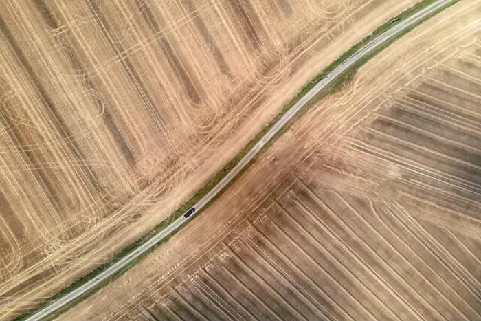Framed Print : car driving on a rural little road surrounded by harvested fields, aerial drone view Framed Print : car driving on a rural little road surrounded by harvested fields, aerial drone view