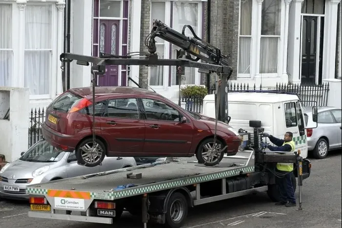 Framed Print : Car being hoisted on to tow away truck in Camden London