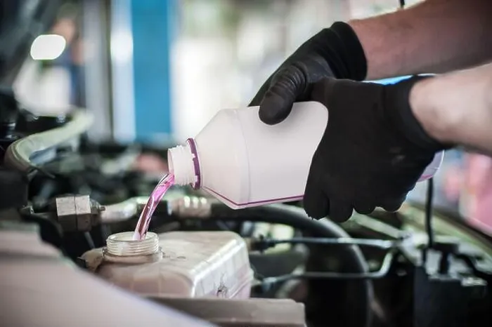 Framed Print : Car master mechanic pours antifreeze in the car at service workshop Framed Print : Car master mechanic pours antifreeze in the car at service workshop