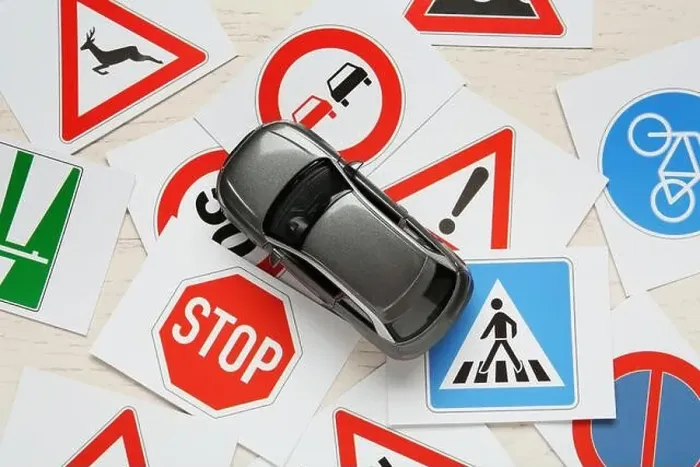 Framed Print : Cards with different road signs and toy car on white wooden table, flat lay. Driving school Framed Print : Cards with different road signs and toy car on white wooden table, flat lay. Driving school