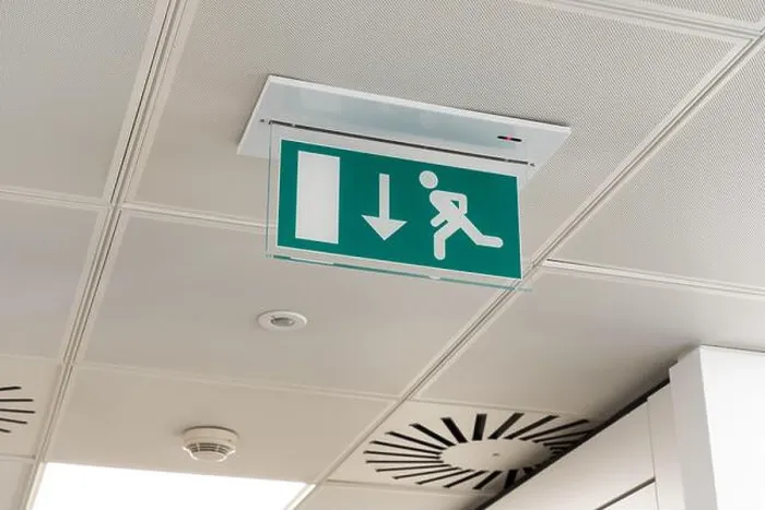 Framed Print : Ceiling mounted LED emergency fire exit sign with arrow pointing towards the fire door in a UK office Framed Print : Ceiling mounted LED emergency fire exit sign with arrow pointing towards the fire door in a UK office