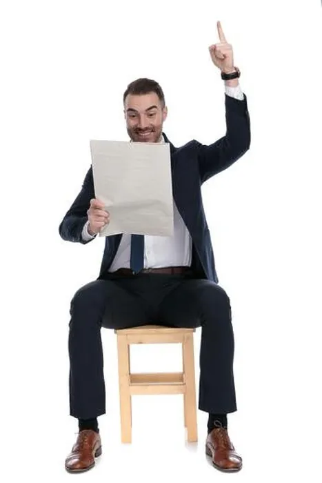 Framed Print : Celebrating businessman holding newspaper and pointing upwards while sitting on a chair on white studio background Framed Print : Celebrating businessman holding newspaper and pointing upwards while sitting on a chair on white studio background