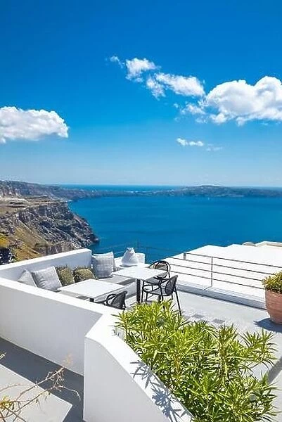 Chairs and table on the terrace. White architecture on Santorini island, Greece. Beautiful view on the sea, vertical banner background. Luxury travel