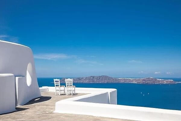 Two chairs on the terrace with sea view. White architecture on Santorini island, Greece. Travel destinations concept, summer holiday, luxury landscape