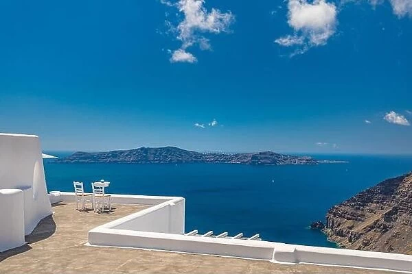 Two chairs on the terrace with sea views. Santorini island, Greece. Travel and vacation background. Luxury summer landscape