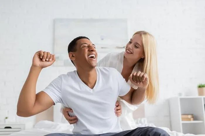 Framed Print : cheerful woman tickling african american boyfriend laughing in bedroom Framed Print : cheerful woman tickling african american boyfriend laughing in bedroom