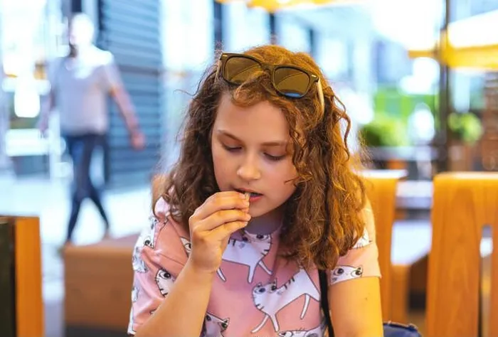 Framed Print : Child girl enjoying french fries Framed Print : Child girl enjoying french fries