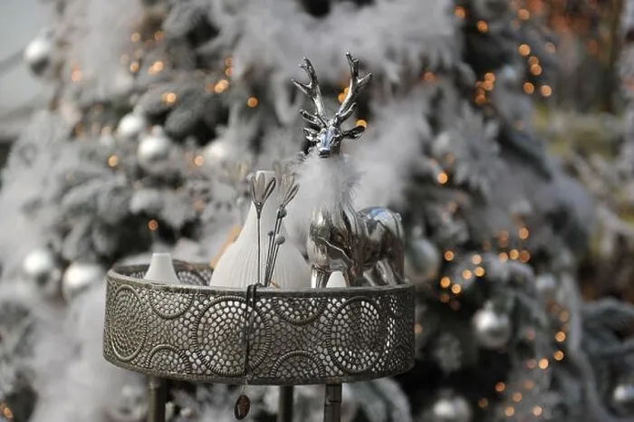 Framed Print : Christmas decoration in interior. A silver deer and a Christmas tree in a background