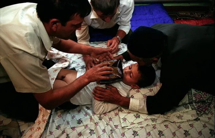 Framed Print : The circumcision master and the closest male relatives of the boy gather near the bed for a prayer Framed Print : The circumcision master and the closest male relatives of the boy gather near the bed for a prayer