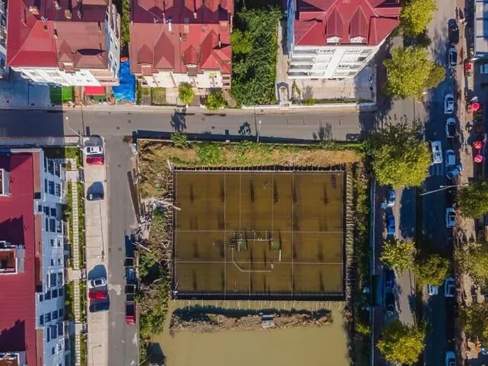 Framed Print : A city street view with a large water field in the middle. The field is surrounded by buildings and trees Framed Print : A city street view with a large water field in the middle. The field is surrounded by buildings and trees