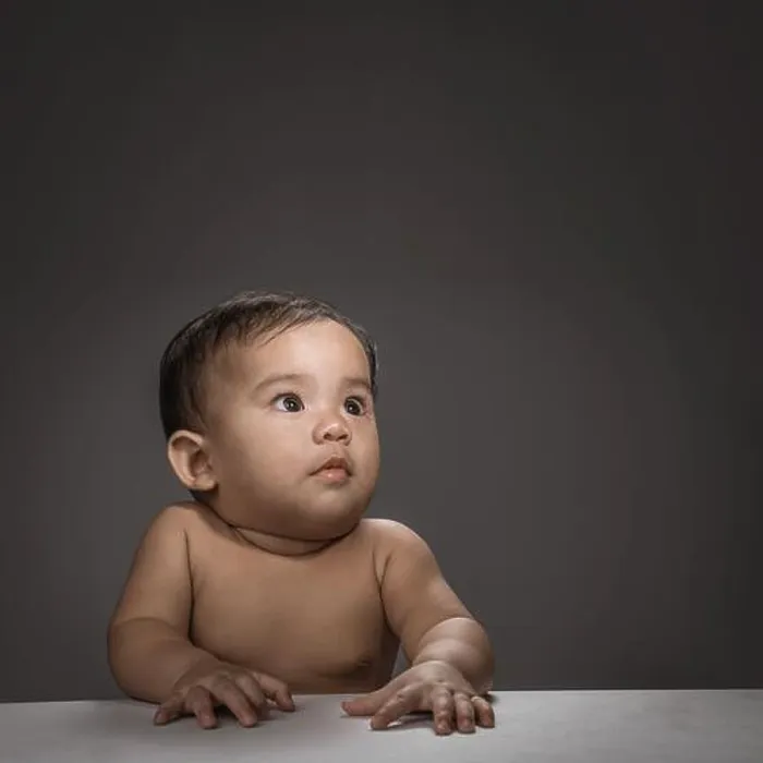 Framed Print : close up of baby face look up thinking over grey background Framed Print : close up of baby face look up thinking over grey background