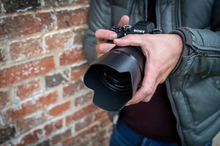 Framed Print : Close up of a male photographer holding a Sony Alpha 9 mirrorless camera Framed Print : Close up of a male photographer holding a Sony Alpha 9 mirrorless camera
