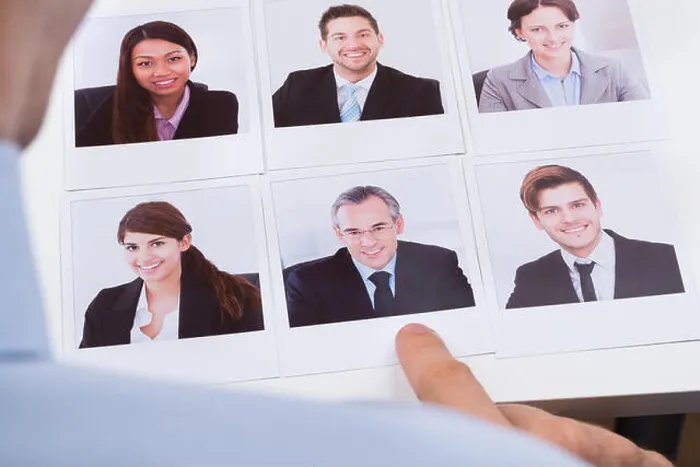 Framed Print : Close-up Of Businessperson Choosing Photograph Of Best Job Candidate Framed Print : Close-up Of Businessperson Choosing Photograph Of Best Job Candidate