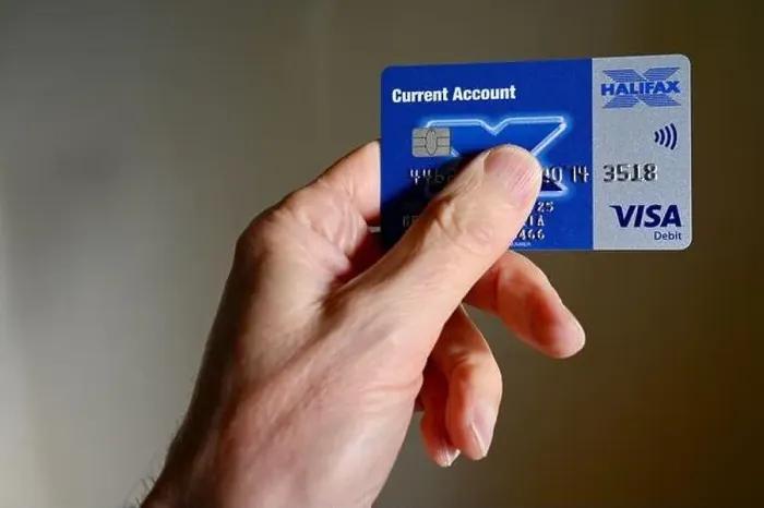 Framed Print : Close-up of senior man holding a Halifax debit card Framed Print : Close-up of senior man holding a Halifax debit card