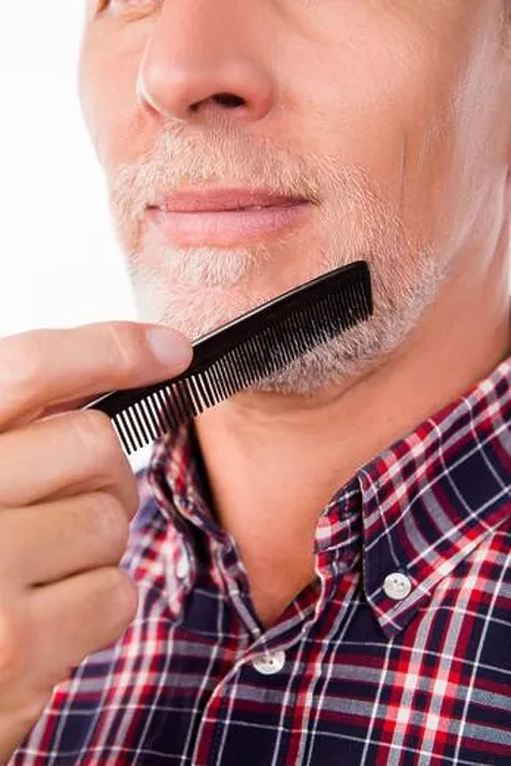Framed Print : Closeup photo of an aged man combing his beard