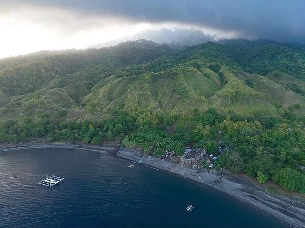 Clouds drift across the remote, volcanic island of Sangeang as it rises from the impressive seascape near Komodo National Park, Indonesia