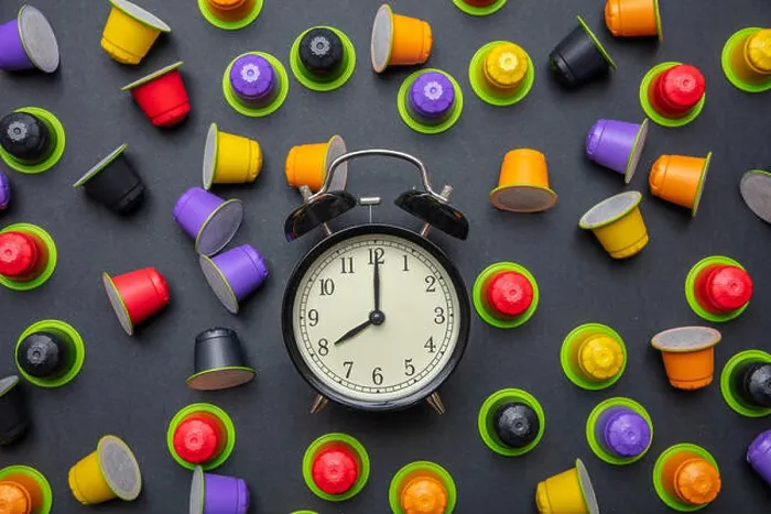 Framed Print : Coffee time. Alarm clock and espresso capsules, pods eco friendly, compostable on black color background, top view Framed Print : Coffee time. Alarm clock and espresso capsules, pods eco friendly, compostable on black color background, top view