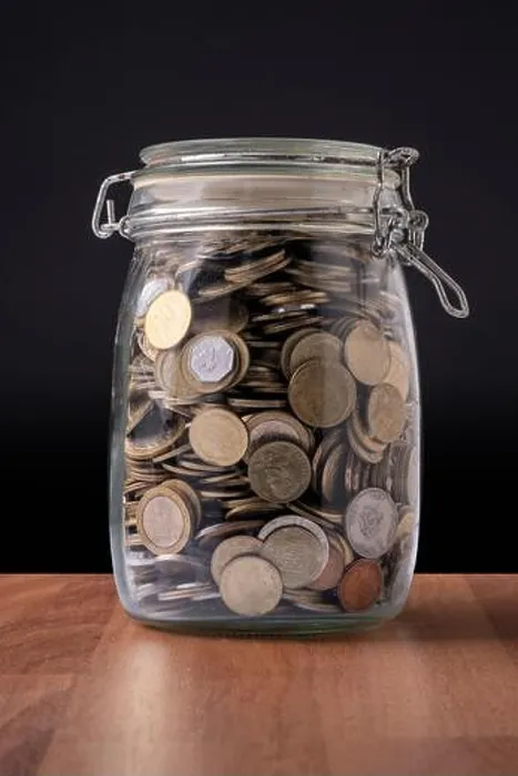 Framed Print : Coins inside a glass container full of money Framed Print : Coins inside a glass container full of money